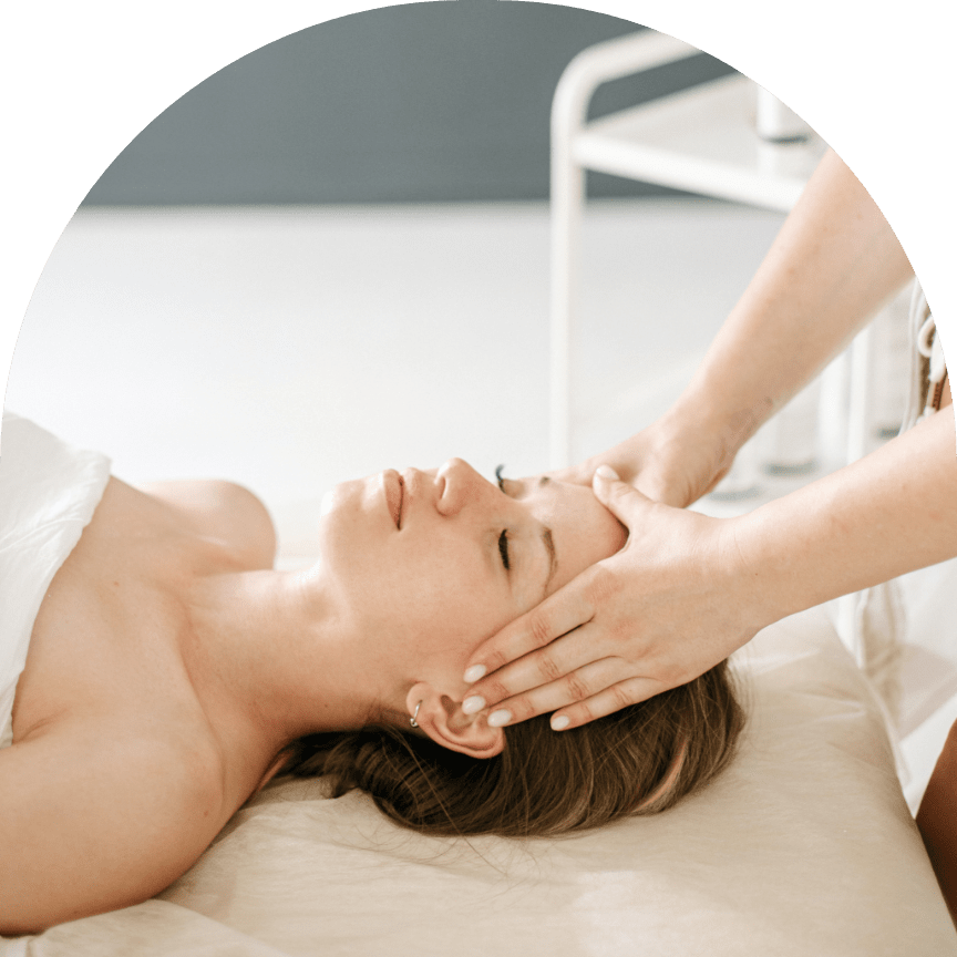 woman on treatment table having face massaged