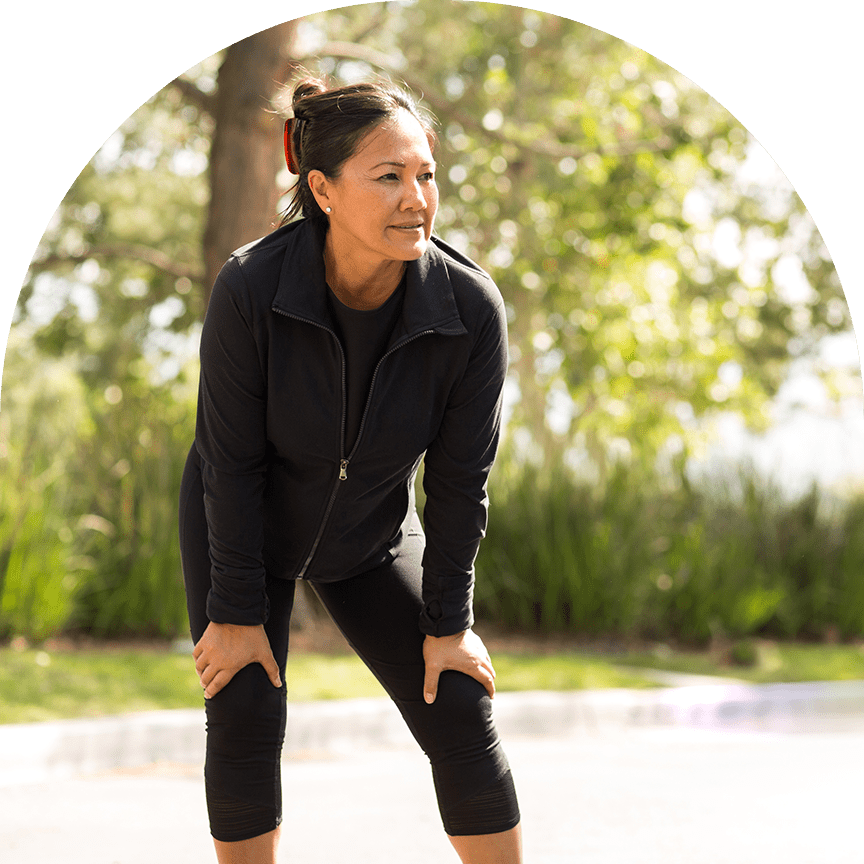 woman pausing to stretch during her run outdoors