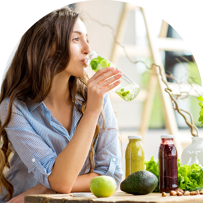 woman sitting at a table drinking fresh pressed juice